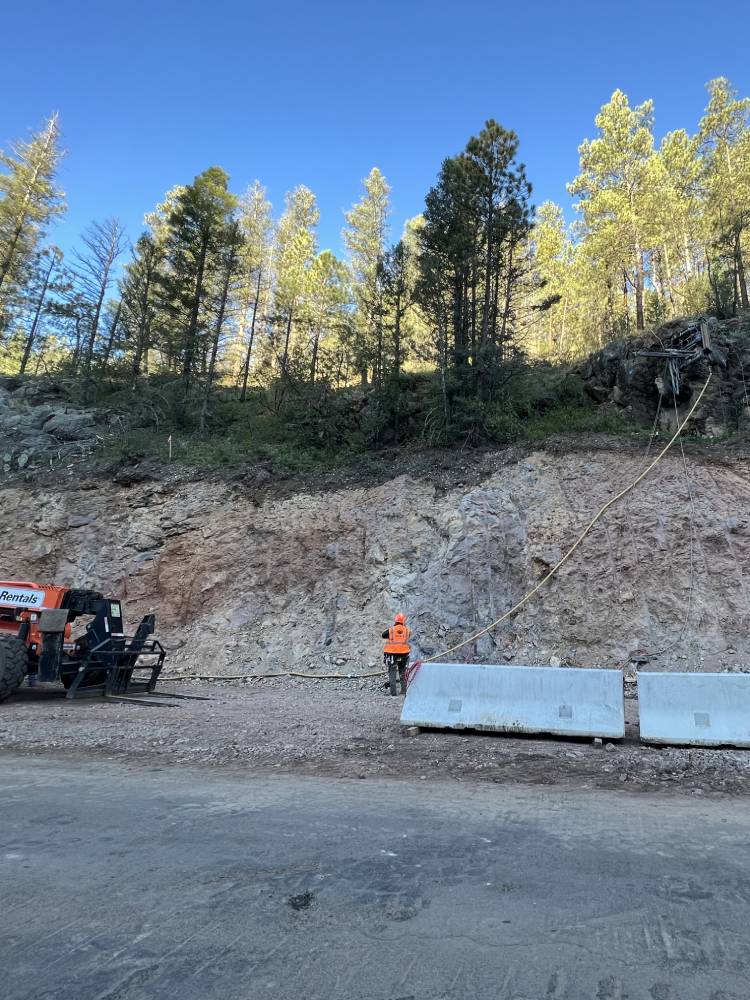 Apex Rockfall Mitigation, NMDOT 434, Angel Fire New Mexico, Performed alignment checks for azimuth and inclination, using down-the-hole equipment, on all of the drill holes for the tensioned Rock Bolts; performed water tightness testing on 6 out of 31 tensioned rock bolts.